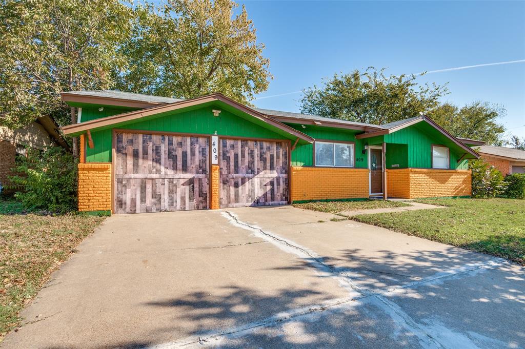 409 Roberts Circle Arlington, TX 76010 - Photo 3 of 25 a front view of a house with a yard and garage