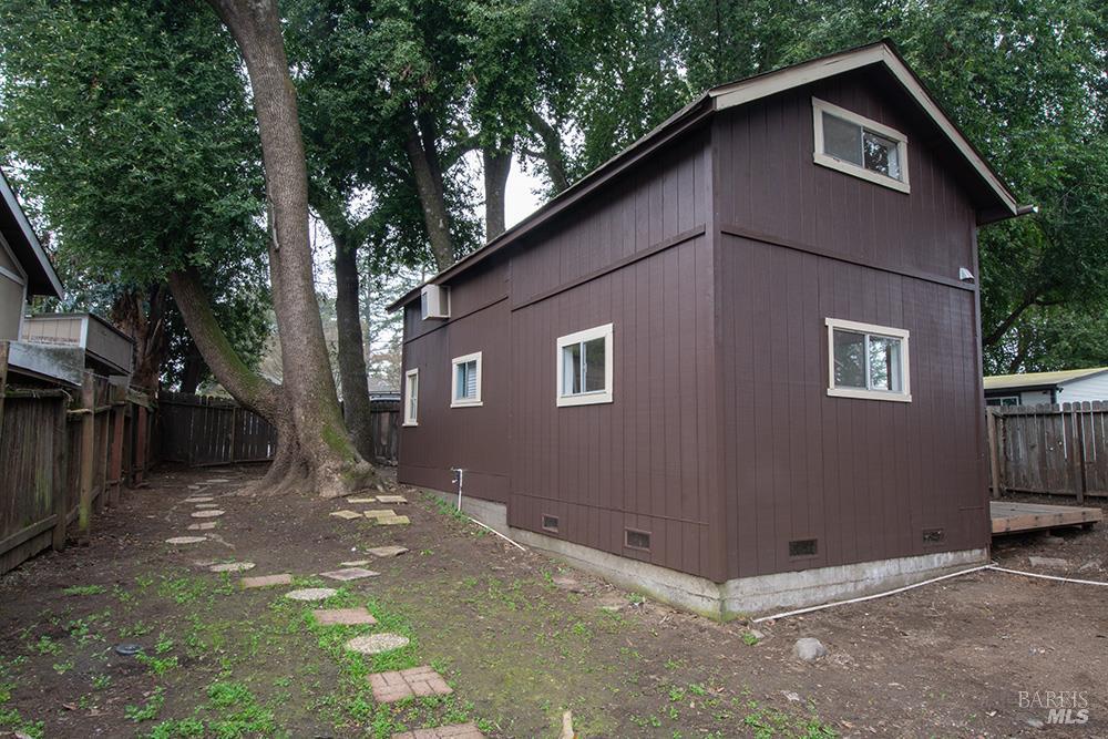 a backyard of a house with large trees and parked