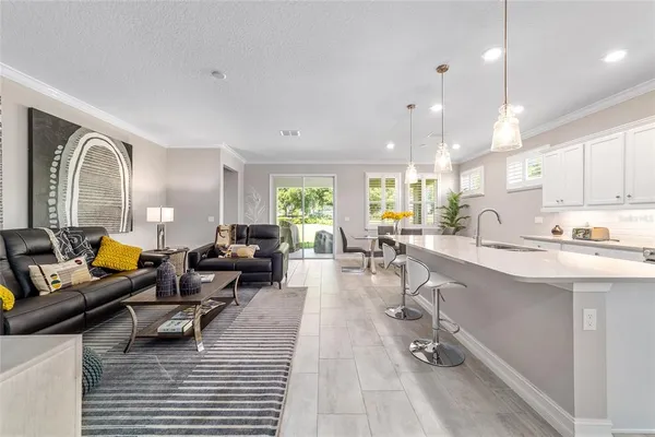 a living room with couches and a dining table with kitchen view