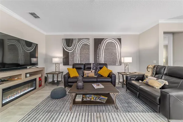 a dining room with furniture a chandelier and kitchen view