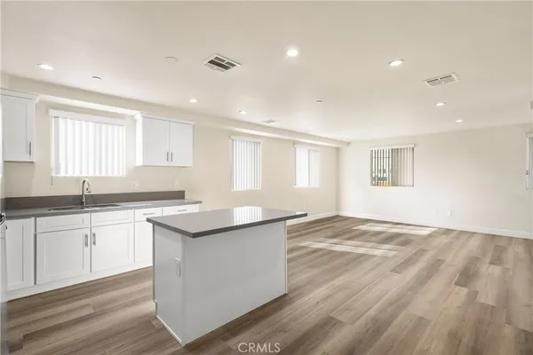 a kitchen with stainless steel appliances kitchen island granite countertop a refrigerator and a stove top oven