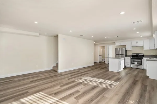 a kitchen with refrigerator cabinets and wooden floor