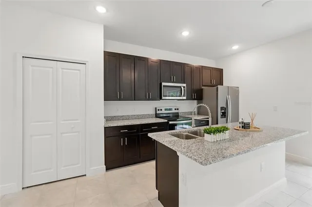 a kitchen with stainless steel appliances granite countertop a sink stove and refrigerator