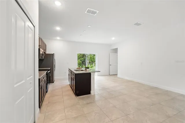 a view of kitchen with refrigerator and window