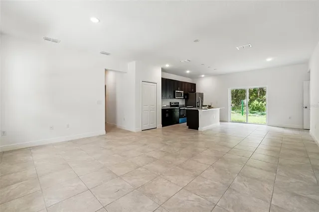 a view of kitchen with refrigerator and windows