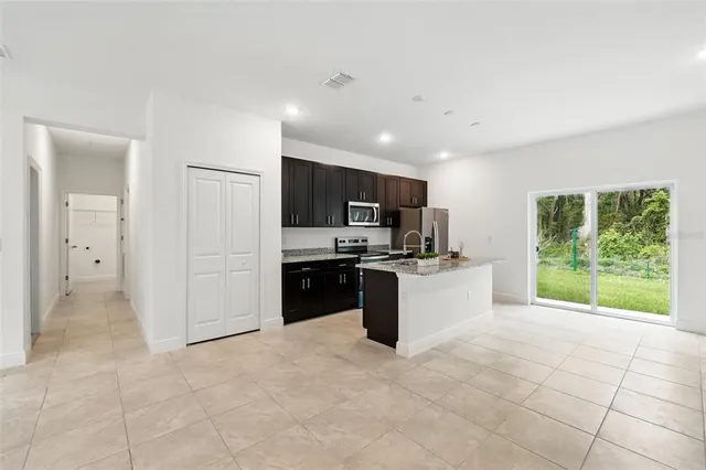 a large kitchen with a large counter top stainless steel appliances and cabinets