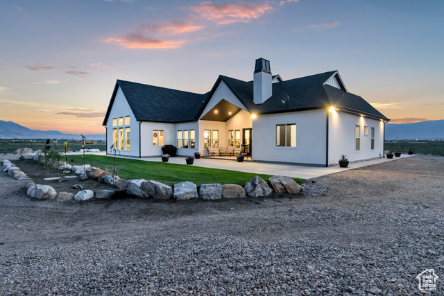 1952 Highway 118 Monroe, UT 84754 - Photo 71 of 88 Back of property featuring a chimney, a patio area, a shingled roof, a lawn, and a mountain view