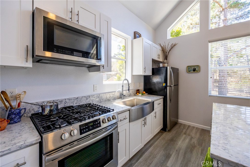 2070 Wales Road Cambria, CA 93428 - Photo 12 of 38 a kitchen with stainless steel appliances a stove a microwave and a window