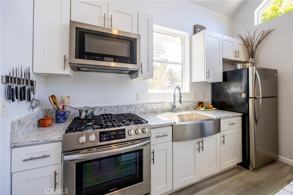 2070 Wales Road Cambria, CA 93428 - Photo 14 of 38 a kitchen with stainless steel appliances a stove a microwave and cabinets