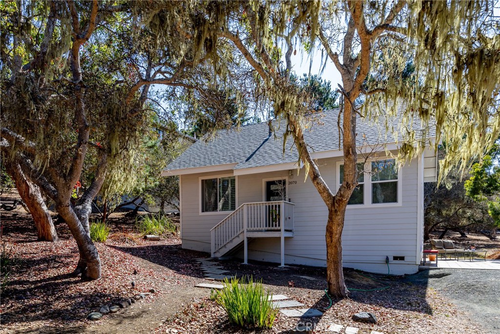 2070 Wales Road Cambria, CA 93428 - Photo 2 of 38 a view of a house with a yard and large tree