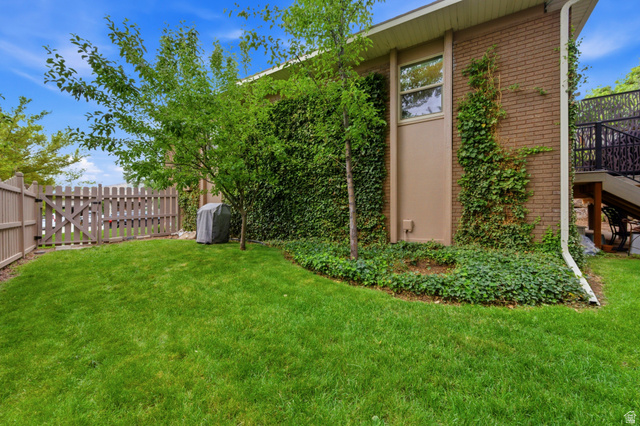 3674 Oak Rim Way Salt Lake City, UT 84109 - Photo 38 of 47 Expansive grassy area with a partial privacy fence and an ornate metal railing staircase