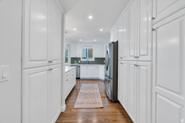 3813 North Foothill Drive Provo, UT 84604 - Photo 18 of 71 Kitchen featuring extensive white cabinetry with brushed nickel hardware, stainless steel refrigerator, recessed lighting, and wood-finish flooring