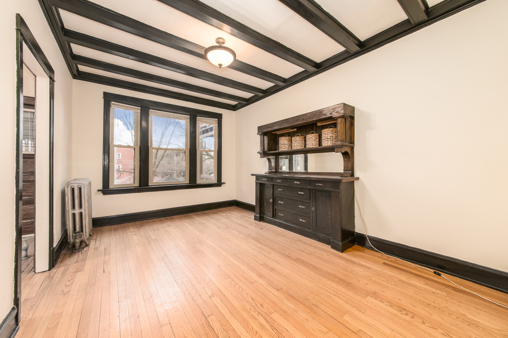 4117 North Paulina Street Chicago, IL 60613 - Photo 11 of 28 a view of an empty room with a window and wooden floor