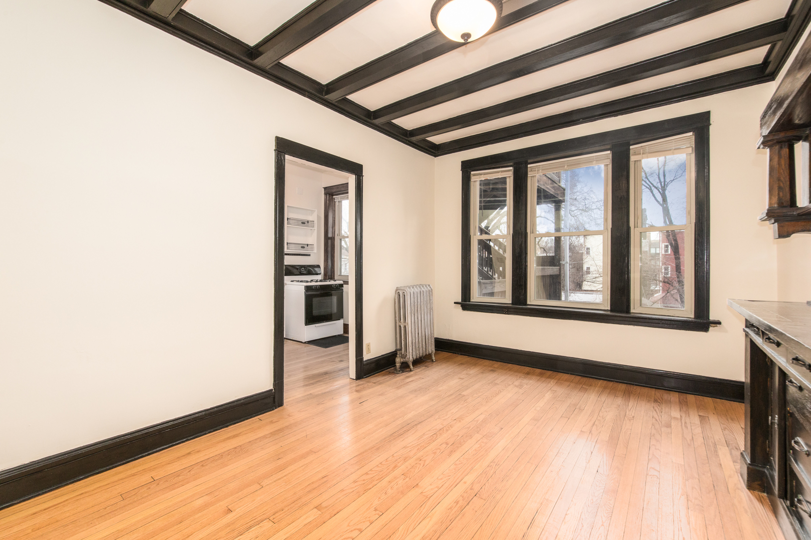 4117 North Paulina Street Chicago, IL 60613 - Photo 12 of 28 a view of an empty room with a window and wooden floor
