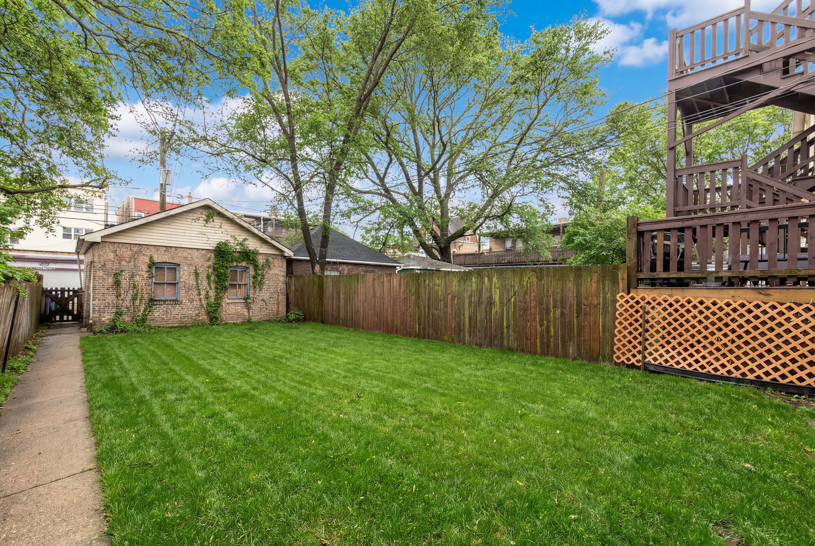 4117 North Paulina Street Chicago, IL 60613 - Photo 4 of 28 a view of a house with a yard and a fence