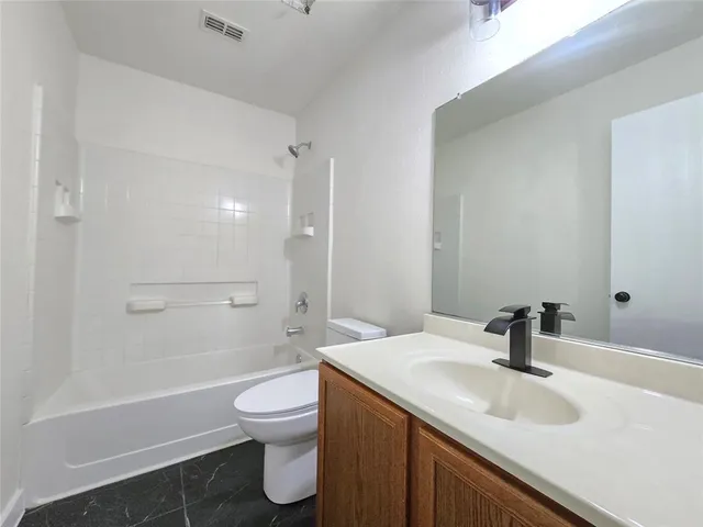 a bathroom with a sink a toilet and a large mirror