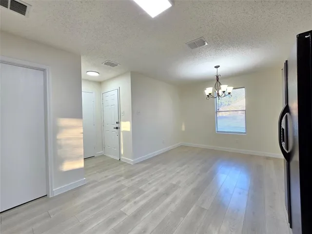 an empty room with wooden floor and window