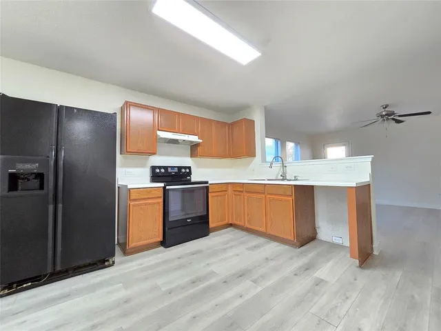a kitchen with stainless steel appliances kitchen island granite countertop a refrigerator and a sink