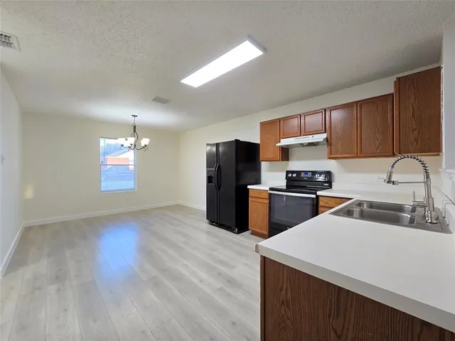 a kitchen with stainless steel appliances a refrigerator sink and microwave