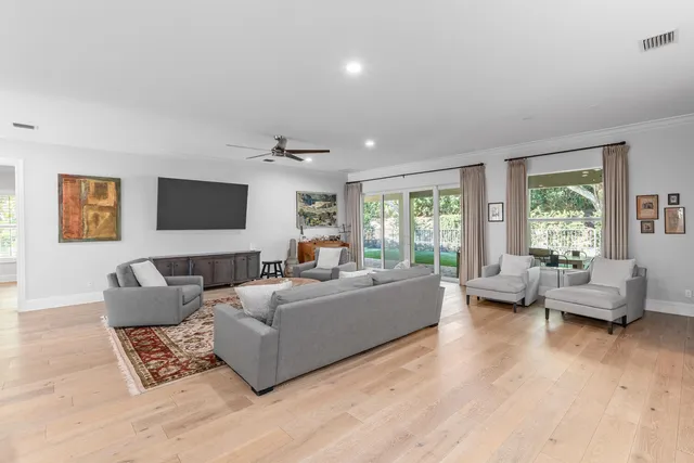 a living room with furniture and a large window with kitchen view