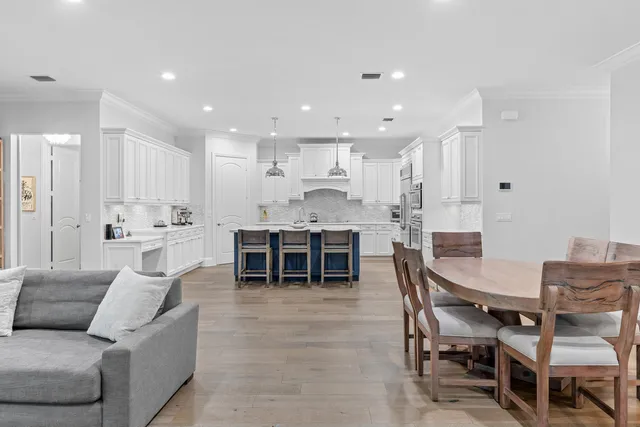 a view of kitchen with kitchen island stainless steel appliances wooden floor dining table and chairs