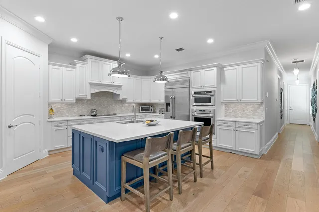 a large kitchen with kitchen island a sink a counter top stainless steel appliances and cabinets