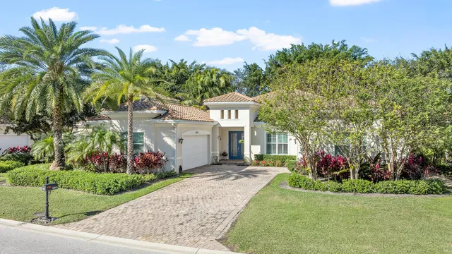 a view of a house with a small yard and palm trees