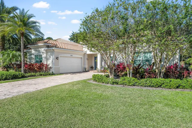 a front view of a house with a yard and potted plants