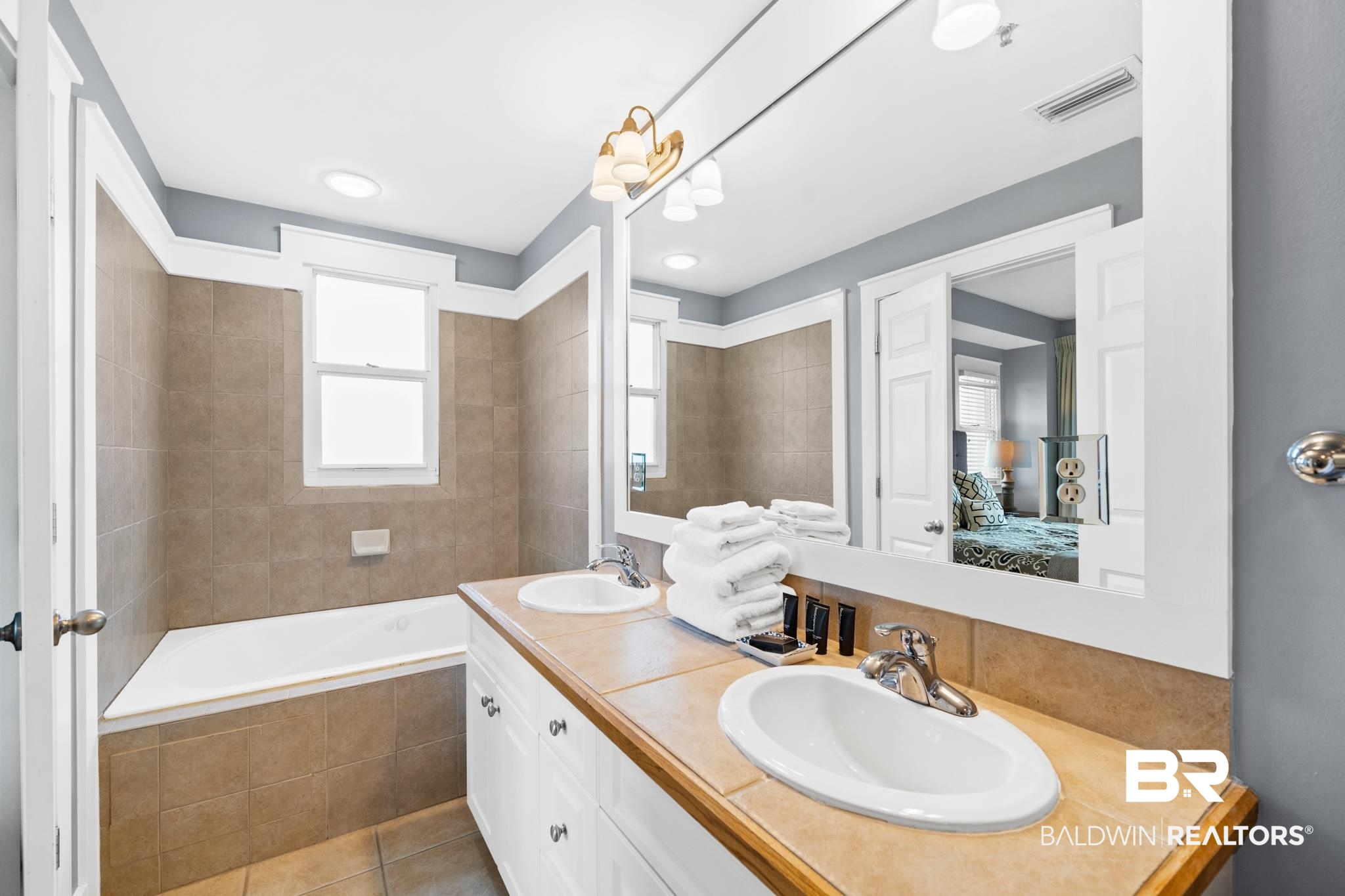 815 Plantation Road, Unit 405 Gulf Shores, AL 36542 - Photo 19 of 39 Bathroom with tiled tub, tile patterned floors, and vanity