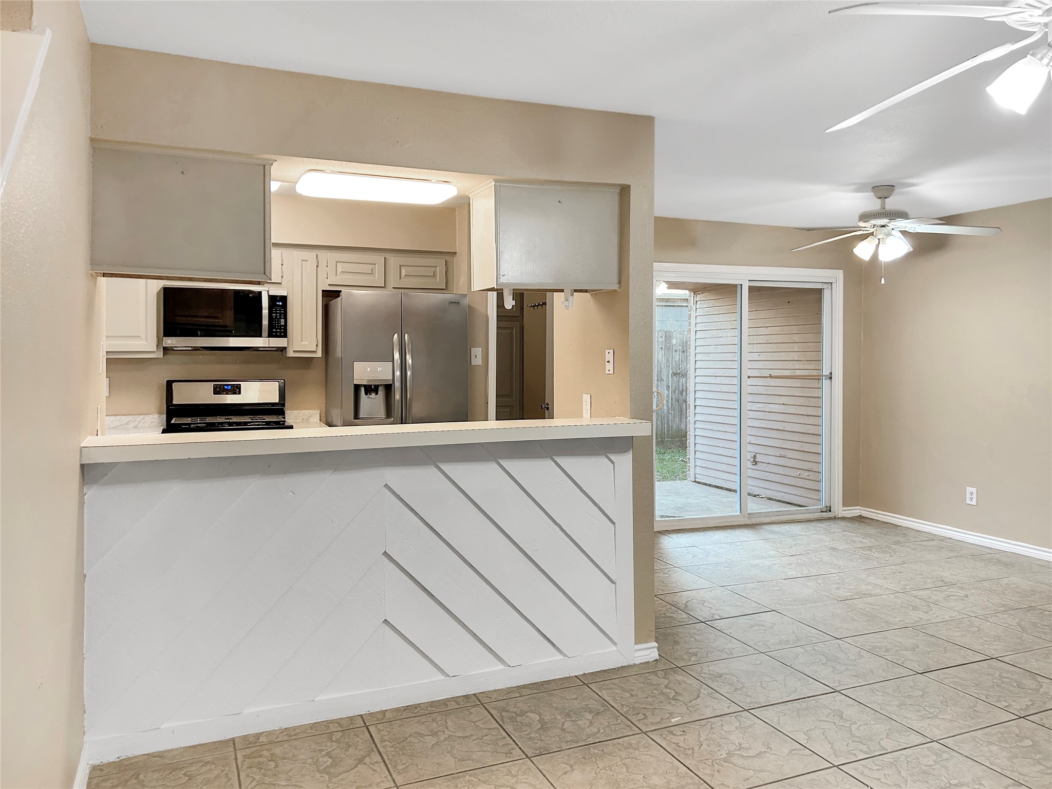 1111 Baker Drive Tomball, TX 77375 - Photo 3 of 16 a kitchen with stainless steel appliances a refrigerator and a stove top oven