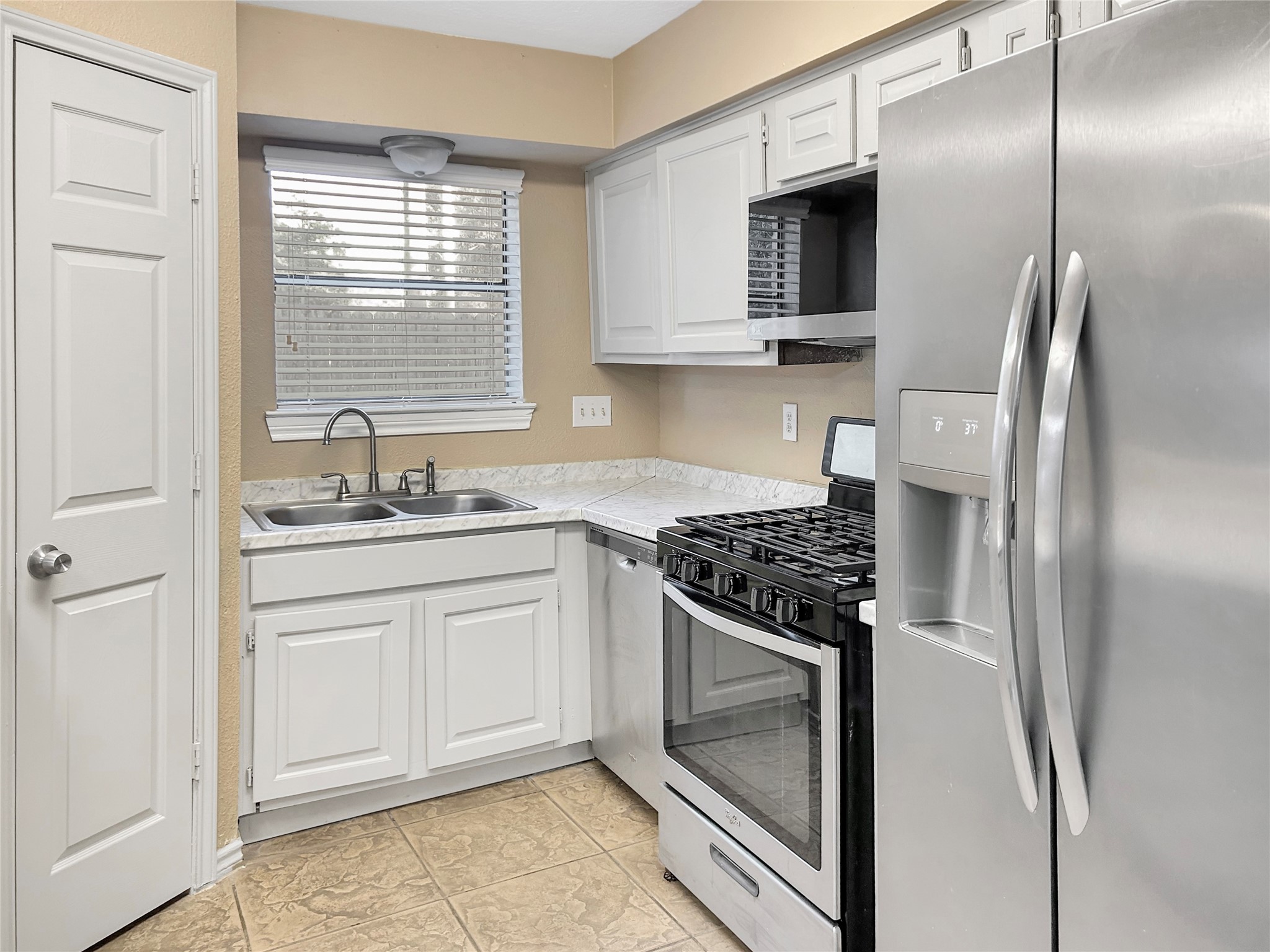 1111 Baker Drive Tomball, TX 77375 - Photo 5 of 16 a kitchen with stainless steel appliances granite countertop a stove a refrigerator and a sink