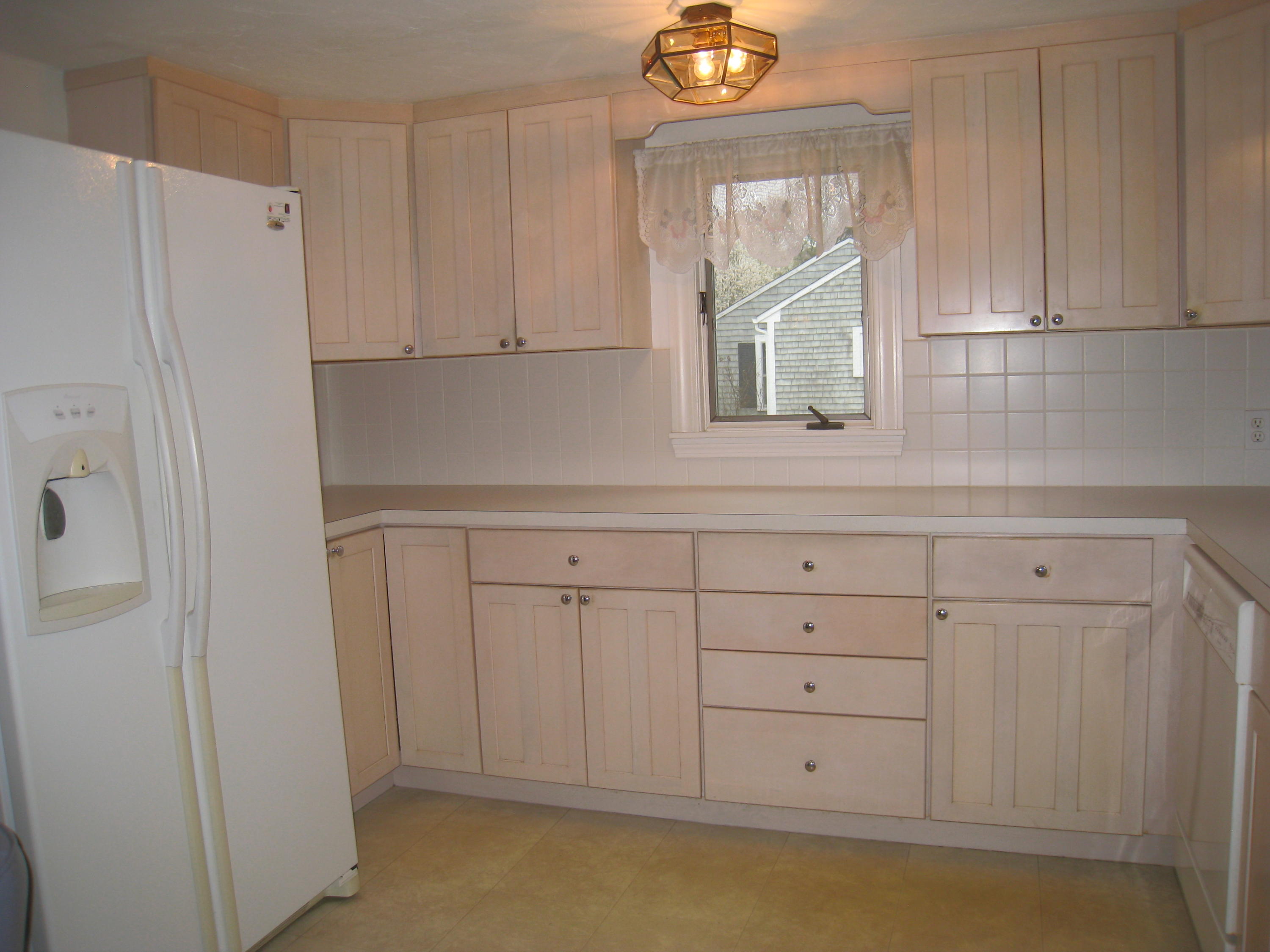 34 Tevyaw Road Hyannis, MA 02601 - Photo 7 of 28 a kitchen with white cabinets and a refrigerator