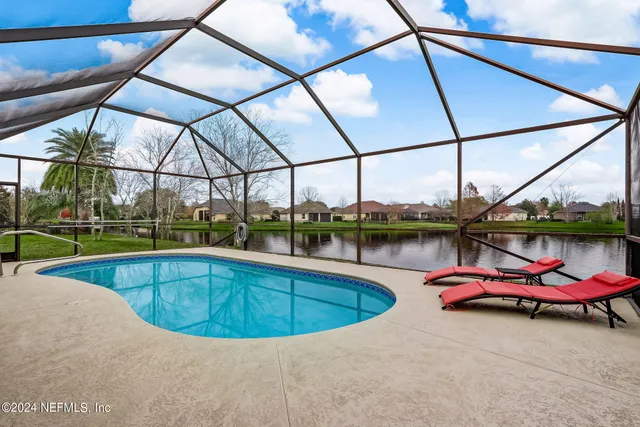 a view of a swimming pool with a chairs in the patio
