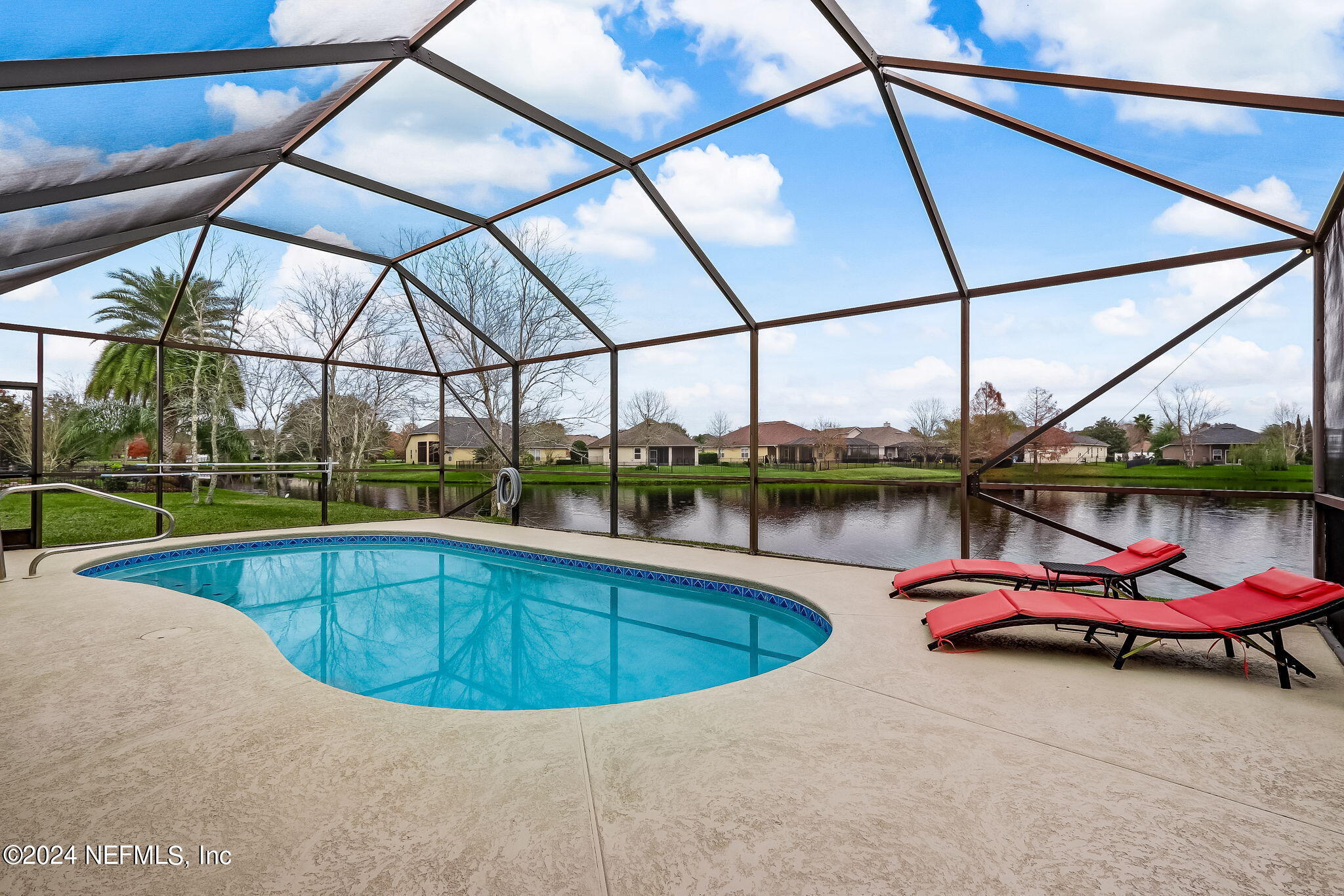 a view of a swimming pool with a chairs in the patio