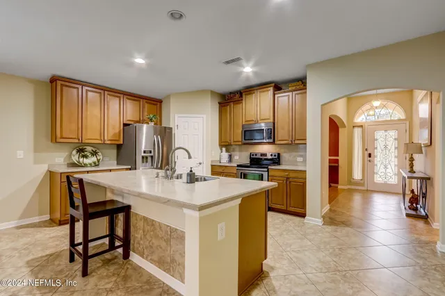 a kitchen with a refrigerator a stove top oven a sink dishwasher and cabinets with wooden floor