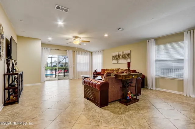 a living room with furniture a chandelier and a large window