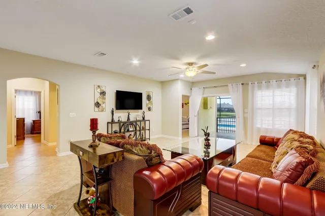 a living room with furniture a flat screen tv and a large window