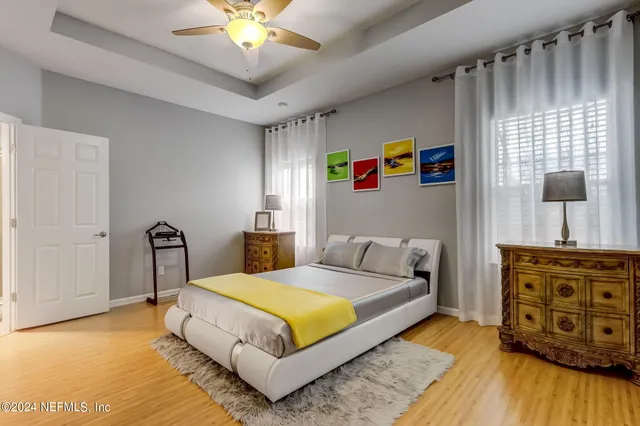 a bedroom with a bed and a flat tv screen on the dresser