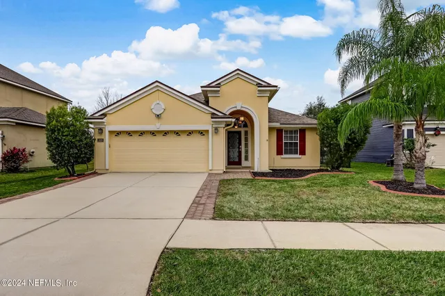 a front view of a house with a yard and garage