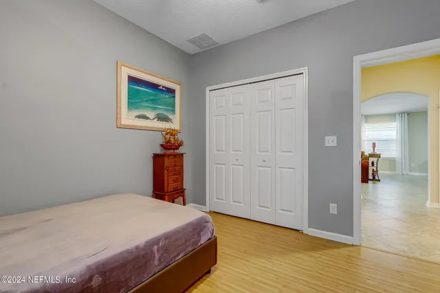 a bedroom with a bed and wooden floor