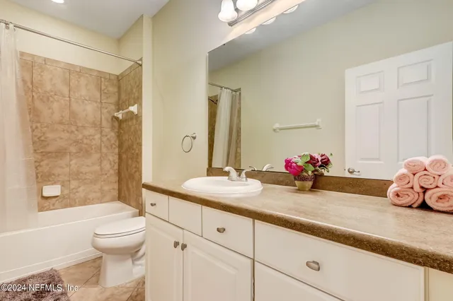 a bathroom with a sink a toilet and a large mirror