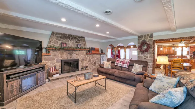 a living room with furniture a flat screen tv and a fireplace