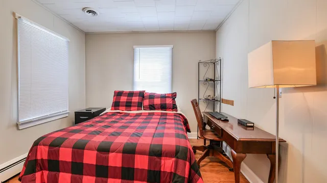 a bedroom with a bed and a lamp next to a window