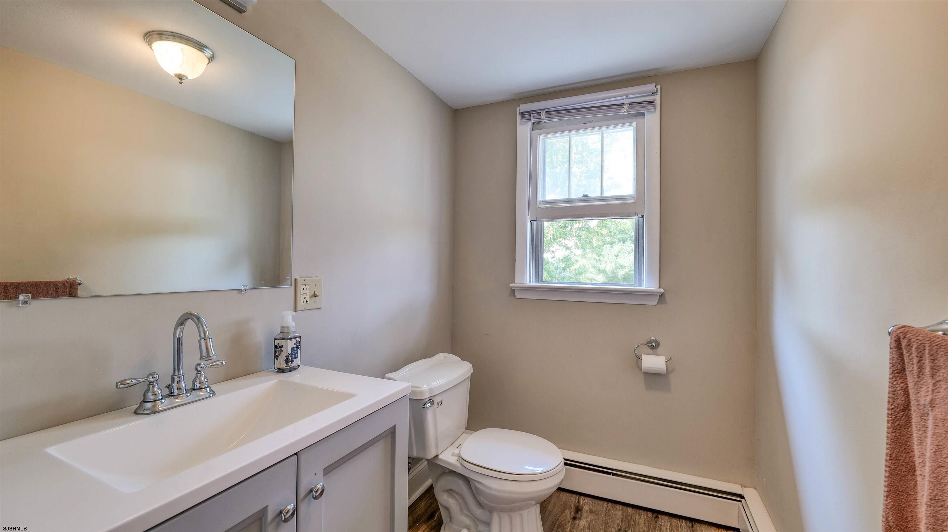 328 Llewellyn Avenue Richland, NJ 08350 - Photo 33 of 44 a bathroom with a toilet a sink a mirror and a window