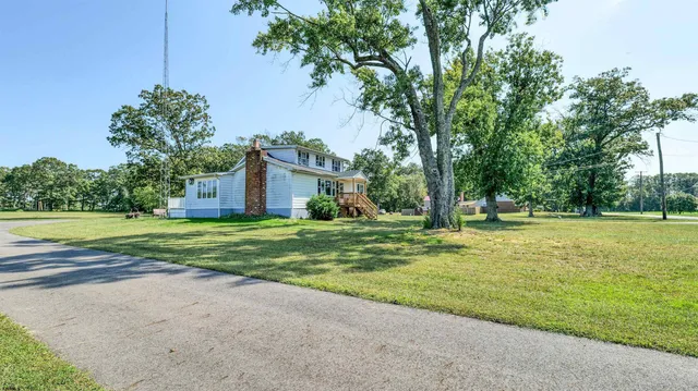 a view of a house with a big yard and palm trees