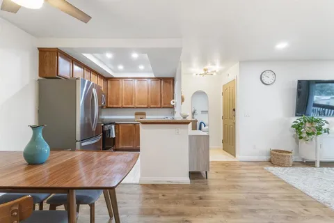 a kitchen with granite countertop a table chairs stainless steel appliances and cabinets