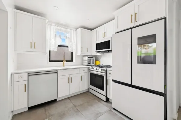 a kitchen with white cabinets and white appliances