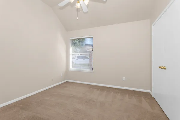 an empty room with a chandelier fan