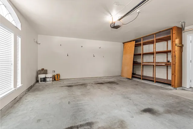 an empty room with cabinet and windows