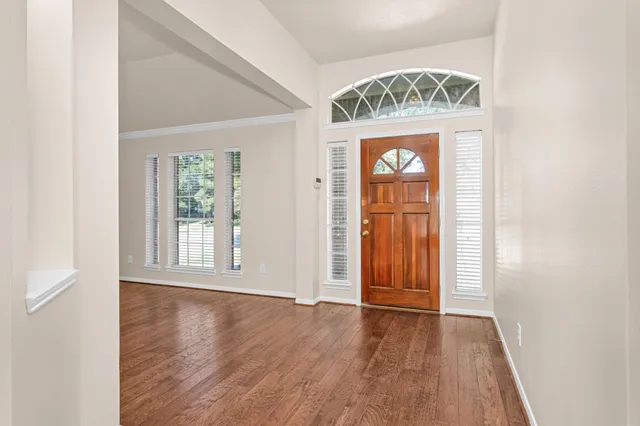 an empty room with wooden floor and a window